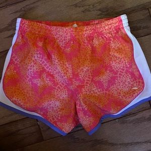 Orange/pink athletic shorts with white and purple lining.